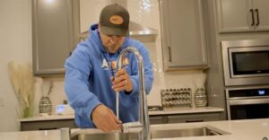 airtech plumber working on a sink in kitchen